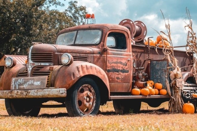a truck parked on the side of a dirt field