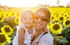 3_original Woman and child smiling in a sunflower field at sunset.